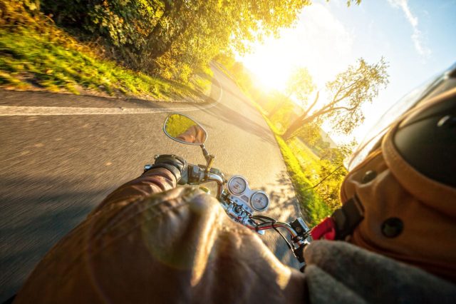 homem a andar de mota na estrada